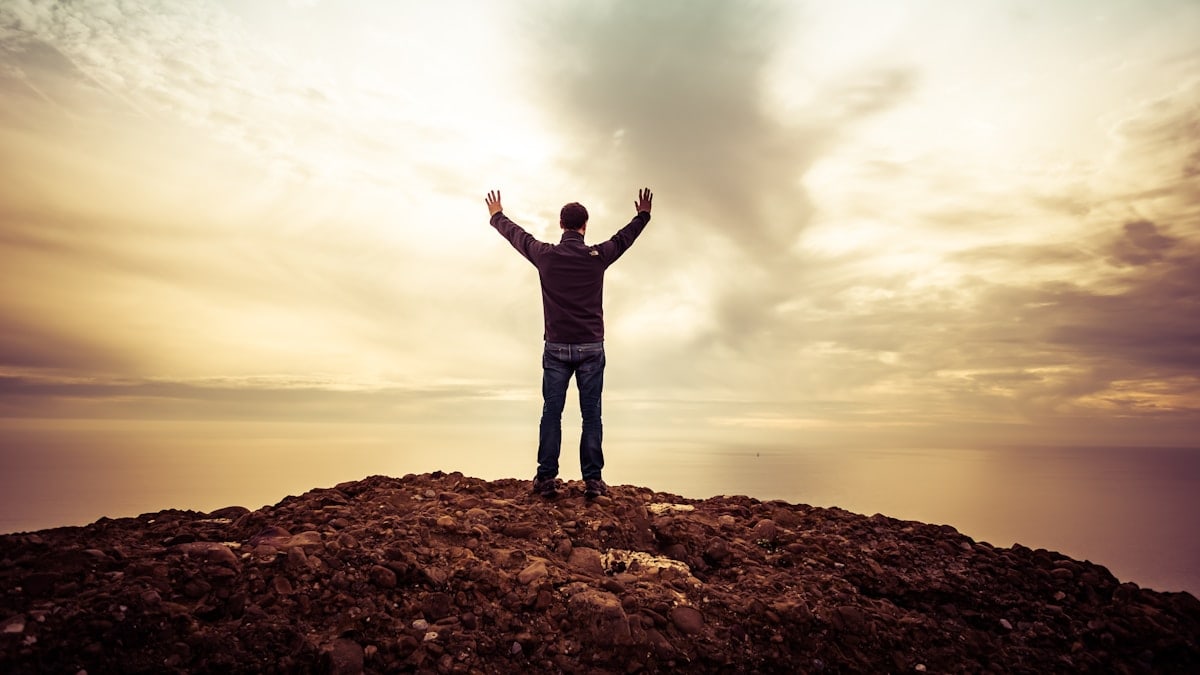 man standing under orange sky